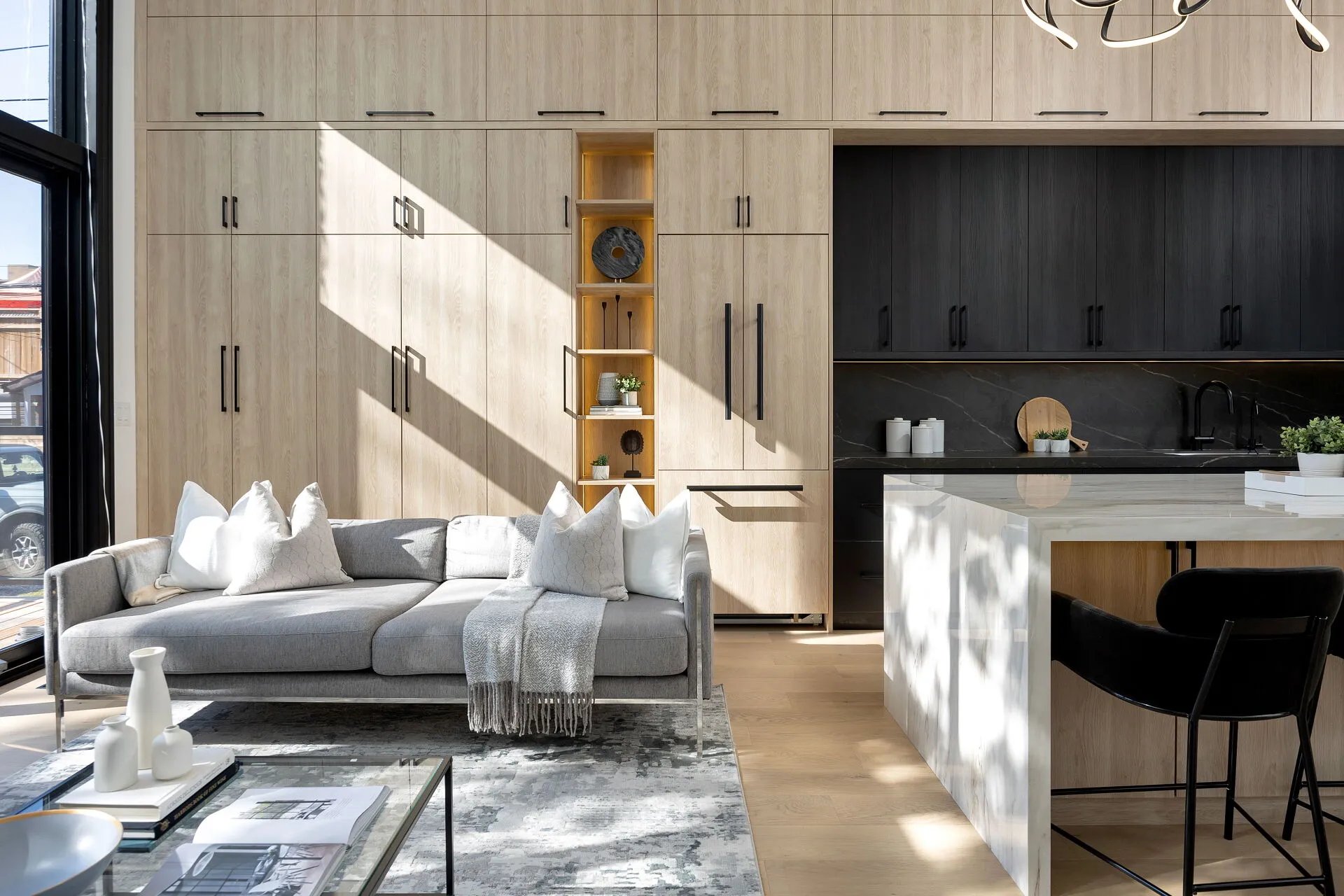 Kav Home Builders open-concept living and kitchen space with white oak millwork and marble island